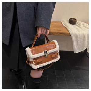 Detail of winter brown leather handbag with plush fleece trim and metal twist lock