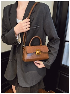 Detail view of dark brown crossbody bag on grey blazer for an elegant minimalist look