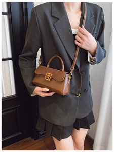 Detail of retro leather crossbody bag with suede patchwork and gold geometric lock