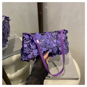 Détail de grandes paillettes mauves sur un sac baguette de soirée brillant et chic