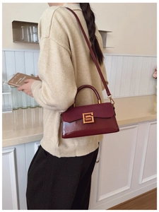 Detail of vintage burgundy shoulder bag showing suede texture and gold buckle