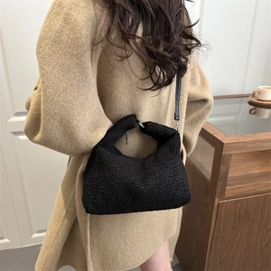 Fashionable black faux lambskin shoulder bag for women shown in a lifestyle setting