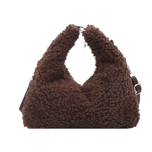 Sac à main en peluche marron foncé avec bandoulière réglable en cuir sur fond blanc