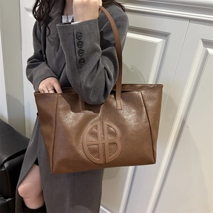 Brown faux leather tote bag with large capacity and circular logo detail