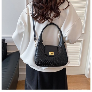 Detail of black Hobo bag featuring crocodile texture and golden heart-shaped twist lock