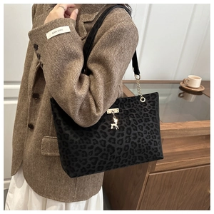 Detailed view of leopard print tote bag with soft faux suede texture and gold deer charm