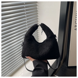 Détail du sac à main noir en peau de mouton avec bandoulière et poignée en peluche