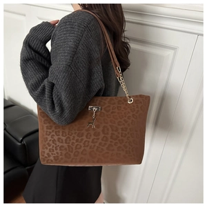 Dettaglio della borsa tote leopardata con tracolla a catena dorata e ciondolo a cervo