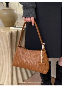 Détail d'un sac en cuir tressé marron avec texture sophistiquée et poignée à nœuds