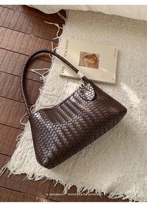 Détail du tissage du sac cabas marron foncé sur un tapis blanc à franges élégant