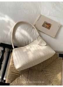 Détail d'un sac hobo minimaliste en cuir tressé crème avec texture sophistiquée et style rétro