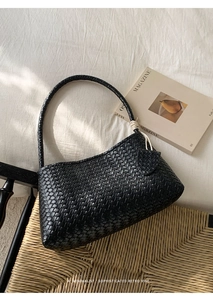 Détail de la texture du sac hobo tissé noir minimaliste avec un charme noué décoratif