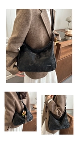 Detail of retro black crescent shoulder bag with Tidal Dryness print and bear charm