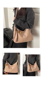 Detail view of khaki tote bag with cute bear charm and woven cord on model shoulder