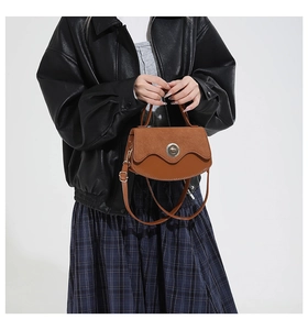 Brown vintage handbag with metal buckle closure and textured patchwork material