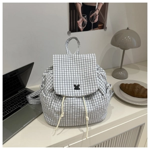 Nahaufnahme des schwarz-weiß karierten Rucksacks mit Kordelzug und Klappendesign