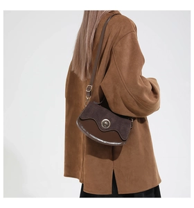 Detail view of the vintage brown suede patchwork shoulder bag with metallic clasp