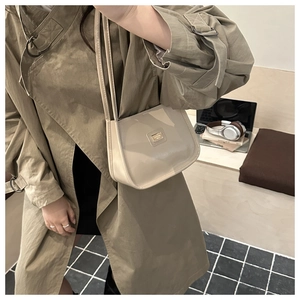 Minimalist beige glossy leather underarm bag with metal plaque for commuters