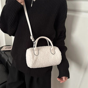 Borsa Boston in pile bianco con cinturini in pelle su un modello con maglione a righe