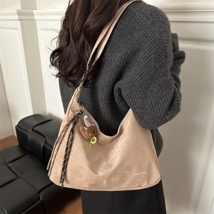 Sac hobo beige minimaliste pour femme avec pompon et pendentif ours, fini doux et chic