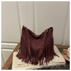 Détail du sac bohème bordeaux à franges avec bandoulière réglable et boucles dorées