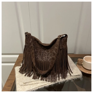 Gros plan du sac bandoulière en daim léopard avec longues franges et bandoulière large