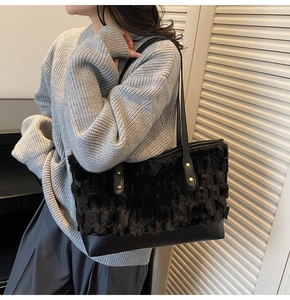 Detail of black faux fur bucket bag with golden rivets and textured patchwork design