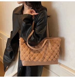 Detail of contrast stitch bucket bag featuring textured faux fur and leather trim