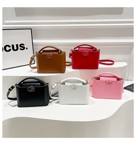 Cinq mini sacs bandoulière de différentes couleurs sur des présentoirs blancs
