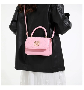 Pink quilted leather crossbody bag with gold M logo shown on model with black jacket