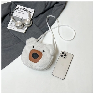 Detail of white plush bear bag with textured brown nose and sleek faux leather strap