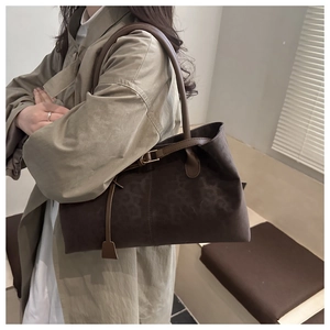 Detail of large brown suede tote bag with leopard print and buckle strap