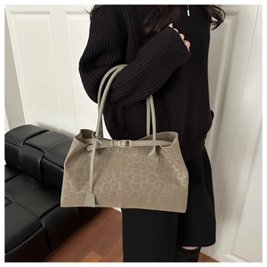 Detail of olive green leopard print tote bag with matte texture and decorative buckle