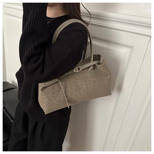 Detail of leopard print tote bag with matte texture and decorative gold buckle strap