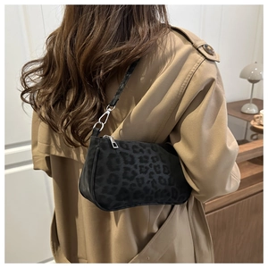 Gros plan du sac sous le bras à motif léopard porté par un mannequin en trench-coat