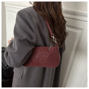 Chic burgundy leopard print baguette bag with silver hardware on model shoulder