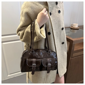 Dettaglio della borsa a spalla in pelle verniciata marrone scuro con due tasche frontali e fibbie