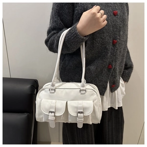 Dettaglio di una borsa a spalla bianca lucida Y2K con due tasche frontali e fibbie