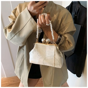 Détail du sac à main vintage blanc avec imprimé bambou et fermoir à perles géantes