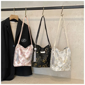 Détail des sacs en satin avec imprimé papillon et glands élégants en trois couleurs