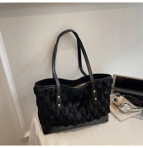 Detail of black fuzzy tote bag featuring plush texture, leather straps and gold rivets
