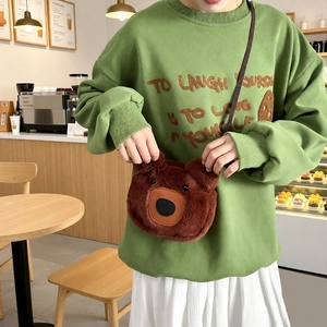 Winter brown plush bear crossbody tote bag styled with a casual green sweatshirt