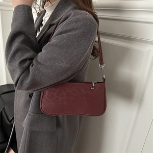 Sac baguette femme rouge foncé à motif léopard porté à l'épaule pour un look élégant