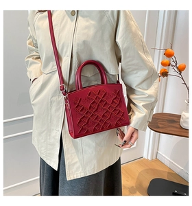 Detail of red quilted lady bag with 3D crown embroidery and adjustable strap