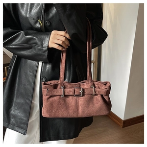 Detail of reddish-brown suede underarm bag with silver buckle and shoulder straps