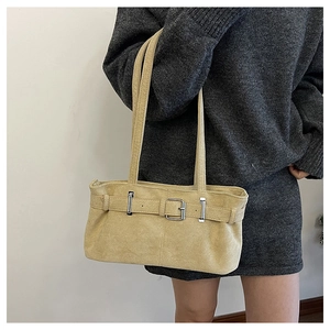 Detail shot of light brown faux suede underarm bag featuring silver buckle and double straps