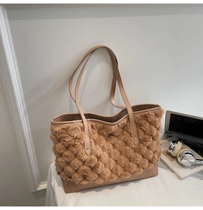 Detail of brown fuzzy bubble texture tote bag with leather base in a minimalist setting