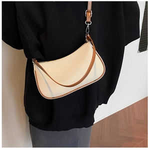 Side view of model wearing a vintage canvas shoulder bag with brown leather trim
