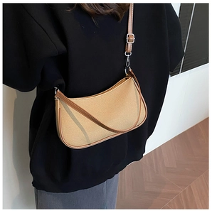 Detail view of khaki canvas hobo bag with brown leather trim and silver hardware
