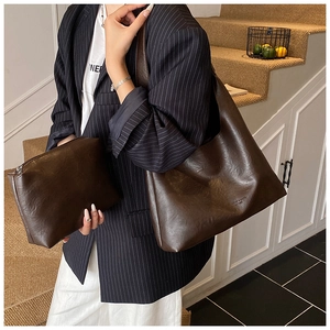 Detail of dark brown tote bag set with pebble grain leather texture and inner pouch